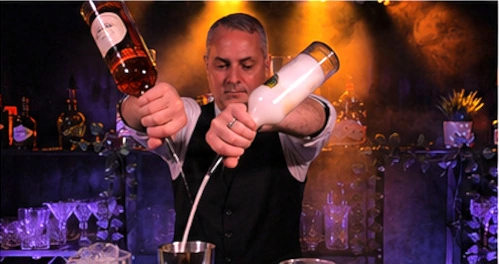 Barman versant deux ingrédients simultanément